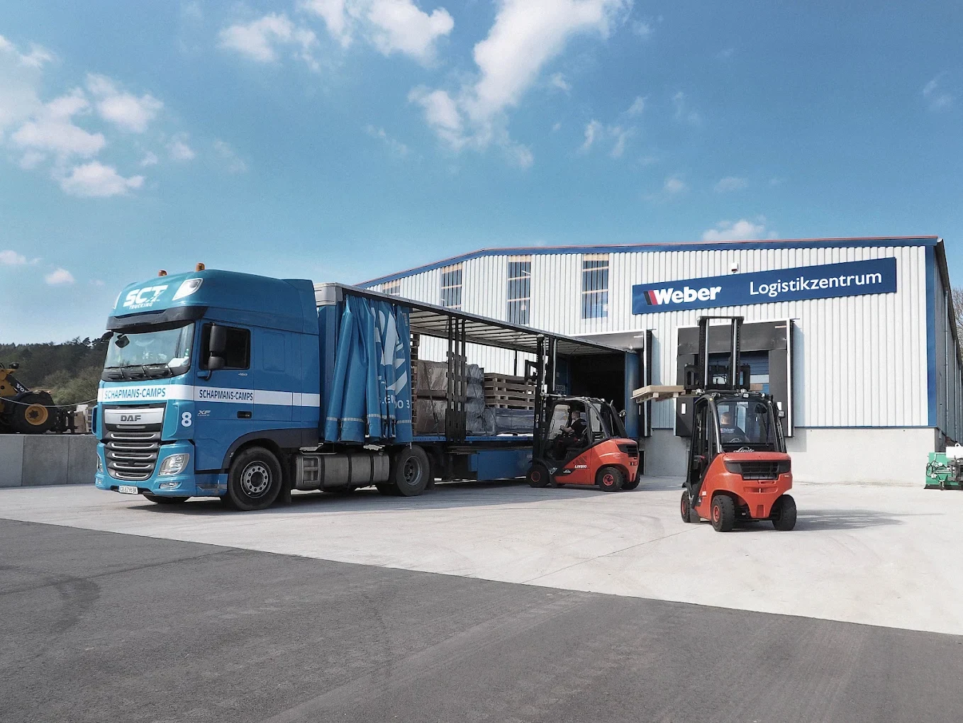 Verladung von Werkstattausrüstung mit Gabelstaplern vor dem Weber Logistikzentrum
